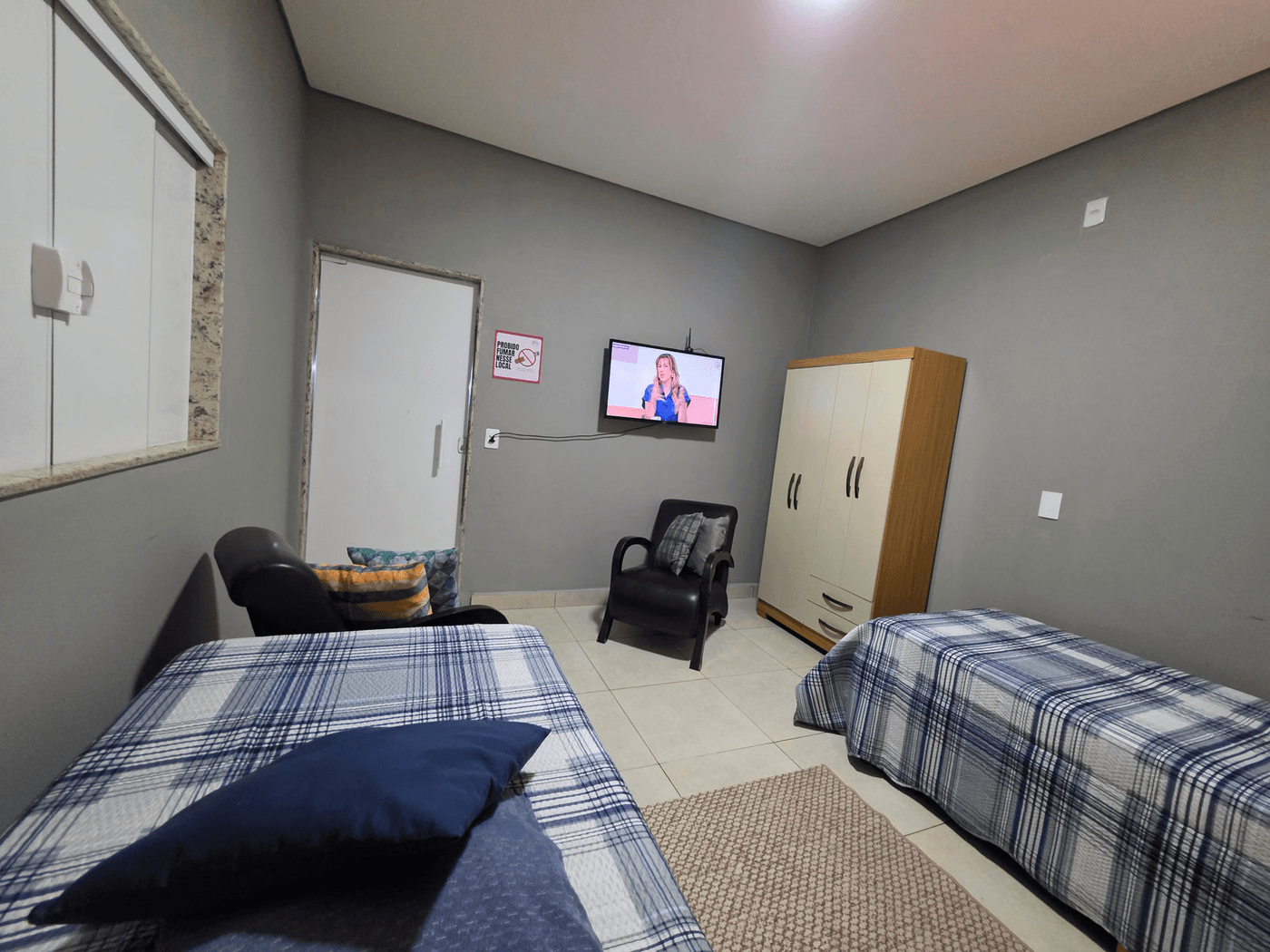 Quarto de apoio com camas e televisão