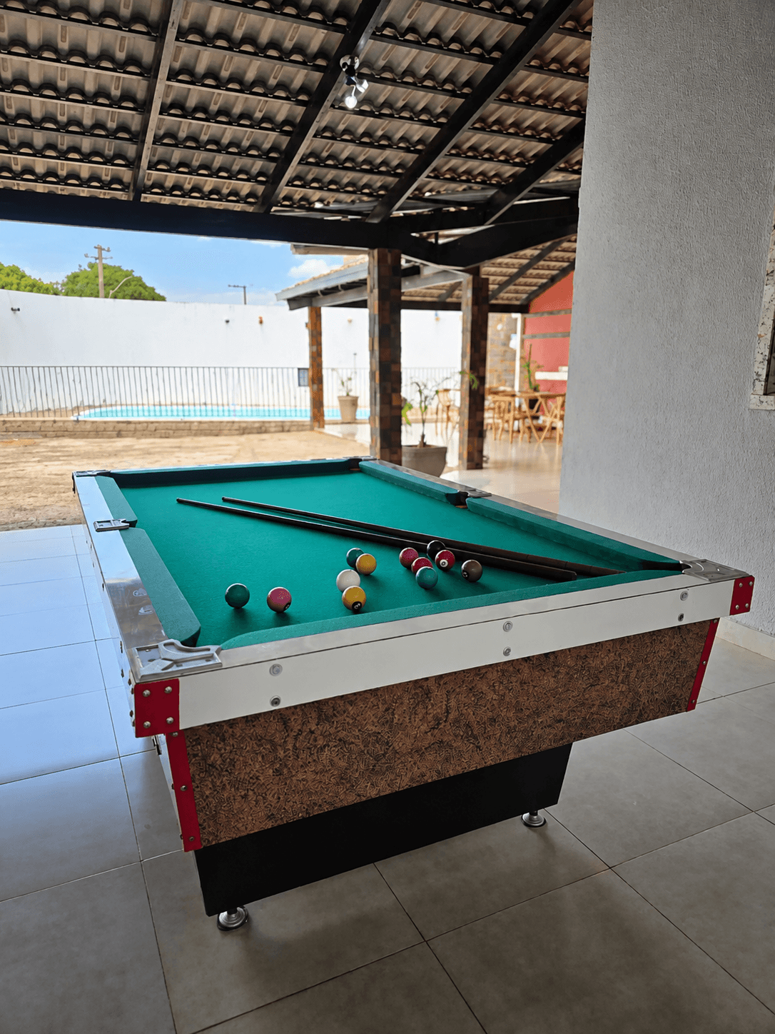 Mesa de sinuca com vista para a piscina